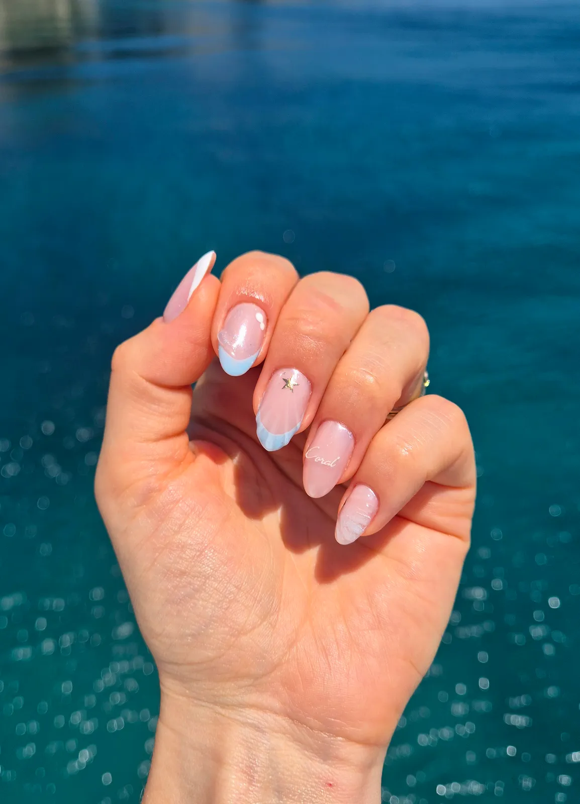 Almond nails with pale blue French tips and a crystal